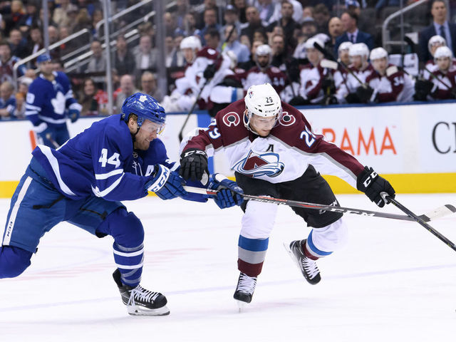 TORONTO, ON - JANUARY 14: Toronto Maple Leafs Defenceman Morgan Rielly (44) and Colorado Avalanche Center Nathan MacKinnon (29) reach for the puck during the first period of the NHL regular season game between the Colorado Avalanche and the Toronto Maple Leafs on January 14, 2019, at Scotiabank Arena in Toronto, ON, Canada.