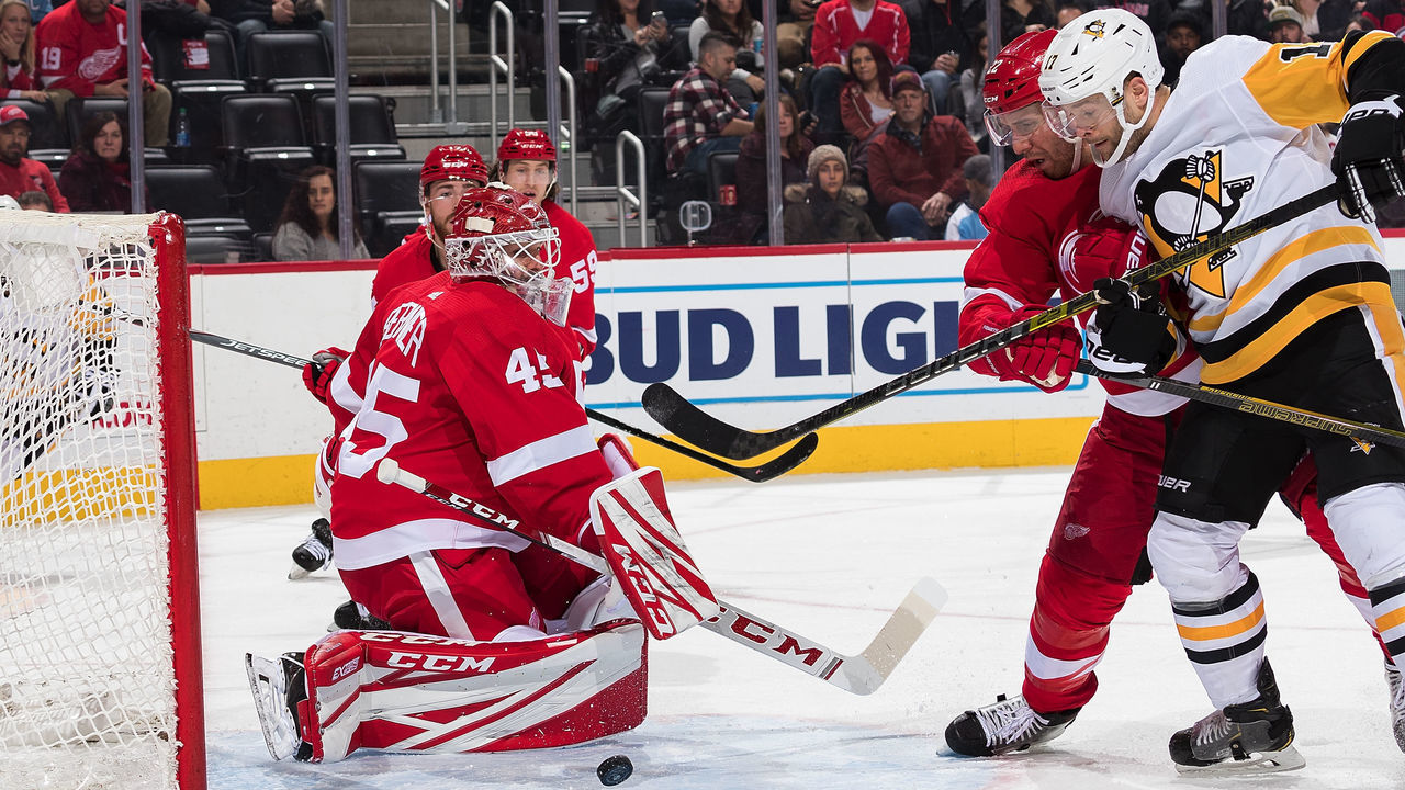 DETROIT, MI - DECEMBER 07: Bryan Rust #17 of the Pittsburgh Penguins battles for the puck with Patrik Nemeth #22 of the Detroit Red Wings in front of goaltender Jonathan Bernier #45 of the Wings during an NHL game at Little Caesars Arena on December 7, 2019 in Detroit, Michigan.