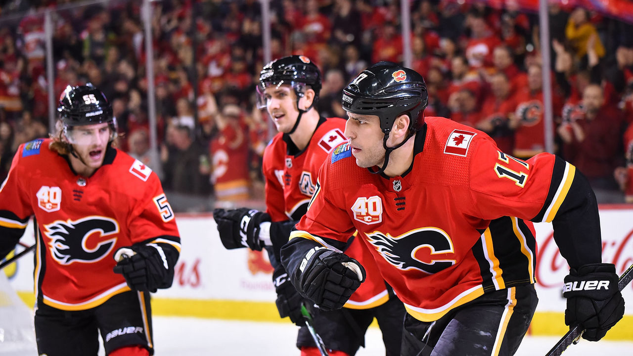 CALGARY, AB - DECEMBER 05: Calgary Flames Left Wing Milan Lucic (17) celebrates a power play goal against the Los Angeles Kings with Calgary Flames Center Mikael Backlund (11) and Defenceman Noah Hanifin (55) during the first period of an NHL game where the Calgary Flames hosted the Buffalo Sabres on December 5, 2019, at the Scotiabank Saddledome in Calgary, AB.