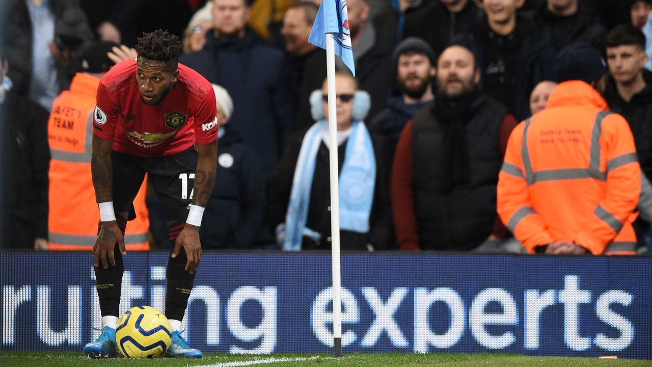 Manchester United's Brazilian midfielder Fred (L) tries to take a corner kick after being pelted with objects from the crowd during the English Premier League football match between Manchester City and Manchester United at the Etihad Stadium in Manchester, north west England, on December 7, 2019. - Fred was hit by objects thrown from the crowd as he prepared to take a corner in the second half while footage on social media appeared to show a City fan mimicking a monkey at the Brazilian.