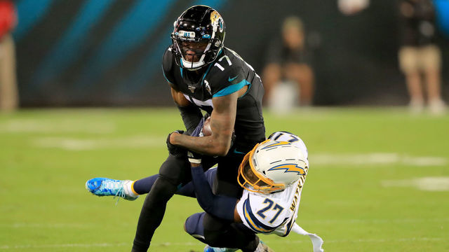 JACKSONVILLE, FLORIDA - DECEMBER 08: Jaylen Watkins #27 of the Los Angeles Chargers attempts to tackle D.J. Chark #17 of the Jacksonville Jaguars during the game at TIAA Bank Field on December 08, 2019 in Jacksonville, Florida.