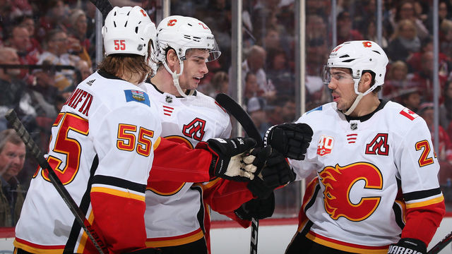 GLENDALE, ARIZONA - DECEMBER 10: Sean Monahan #23 of the Calgary Flames celebrates with Noah Hanifin #55 and Travis Hamonic #24 after scoring a goal against the Arizona Coyotes during the second period of the NHL game at Gila River Arena on December 10, 2019 in Glendale, Arizona.
