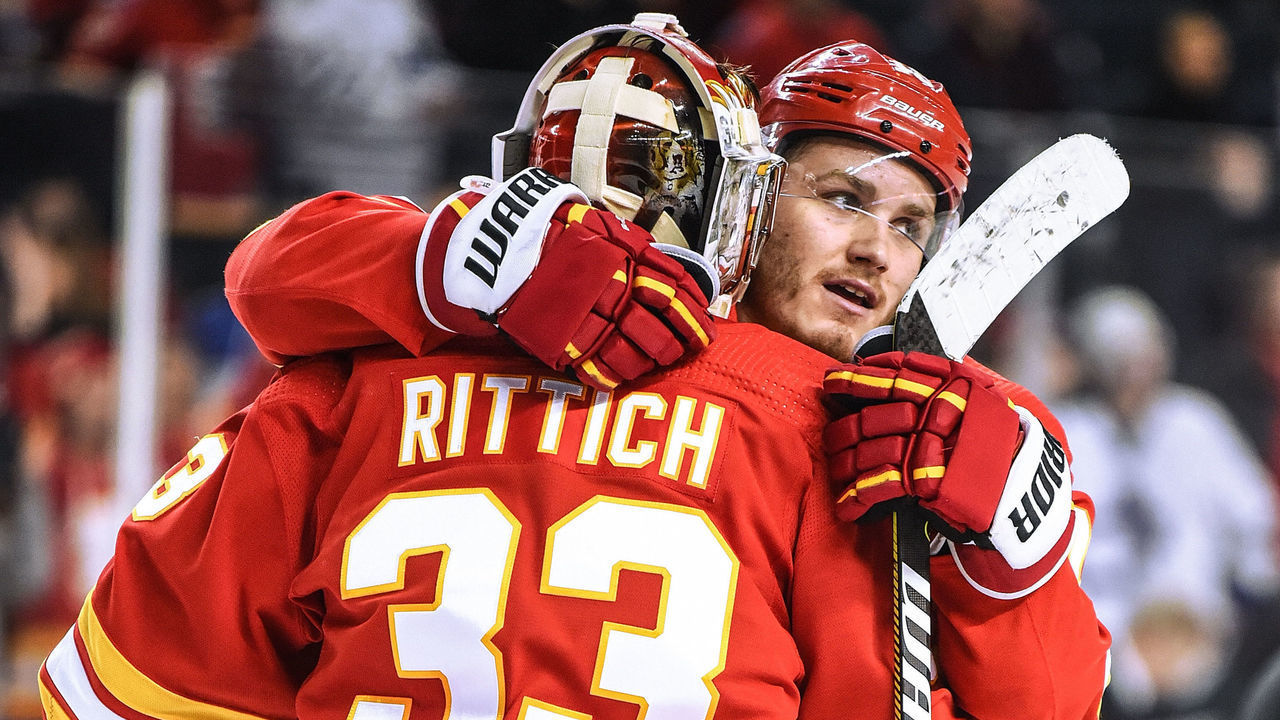 CALGARY, AB - DECEMBER 12: Calgary Flames Goalie David Rittich (33) and Left Wing Matthew Tkachuk (19) hug following their 4-2 win over the Toronto Maple Leafs on December 12, 2019, at the Scotiabank Saddledome in Calgary, AB.