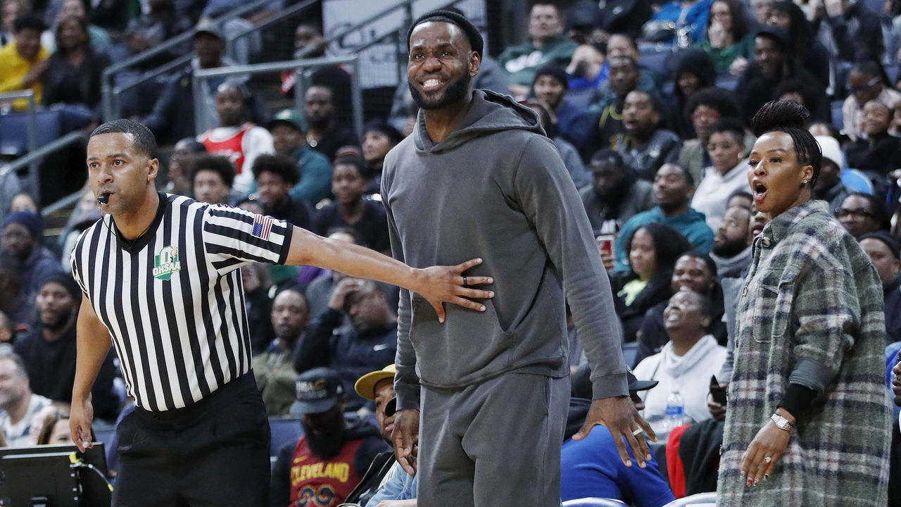 COLUMBUS, OH - DECEMBER 14: LeBron James of the Los Angeles Lakers is restrained by a referee while watching son Bronny play with Sierra Canyon High School during the Ohio Scholastic Play-By-Play Classic against St. Vincent-St. Mary High School at Nationwide Arena on December 14, 2019 in Columbus, Ohio.