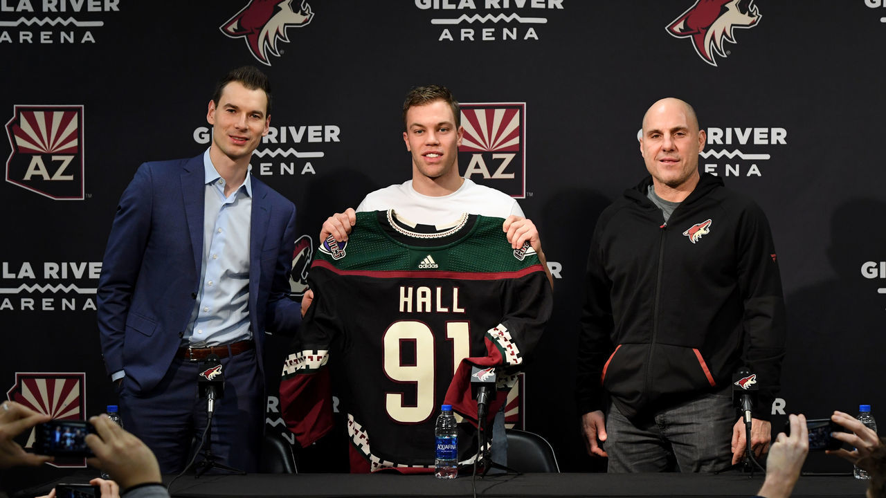 GLENDALE, ARIZONA - DECEMBER 18: Taylor Hall #91 of the Arizona Coyotes holds up his new jersey while standing between head coach Rick Tocchet and general manager John Chayka during a press conference at Gila River Arena on December 18, 2019 in Glendale, Arizona.