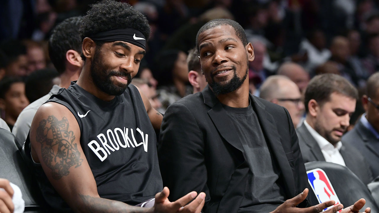 NEW YORK, NEW YORK - NOVEMBER 01: Kyrie Irving #11 and Kevin Durant #7 of the Brooklyn Nets speak on the bench against the Houston Rockets at Barclays Center on November 01, 2019 in New York City. NOTE TO USER: User expressly acknowledges and agrees that, by downloading and/or using this photograph, user is consenting to the terms and conditions of the Getty Images License Agreement.