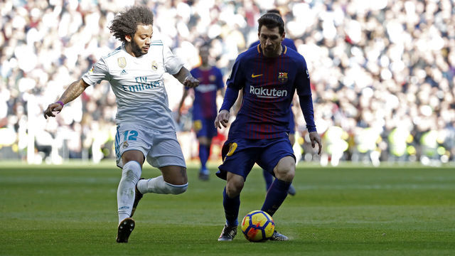 MADRID, SPAIN - DECEMBER 23: Marcelo of Real Madrid and Lionel Messi of Barcelona battle for the ball during the La Liga match between Real Madrid and Barcelona at Estadio Santiago Bernabeu on December 23, 2017 in Madrid, Spain.