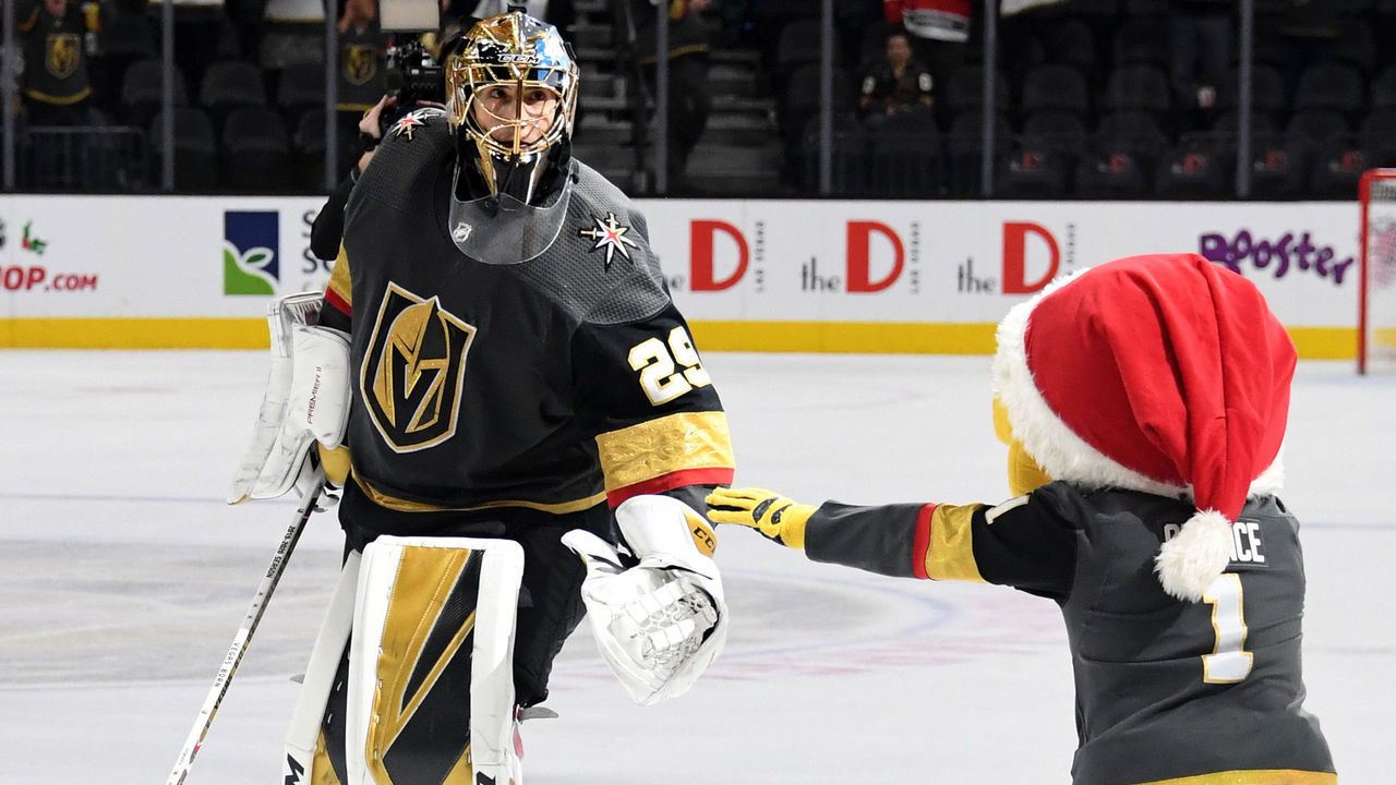 LAS VEGAS, NEVADA - DECEMBER 10: The Vegas Golden Knights mascot Chance the Golden Gila Monster bows down as Marc-Andre Fleury #29 of the Vegas Golden Knights skates on the ice after being named the first star of the game following the team's 5-1 victory over the Chicago Blackhawks at T-Mobile Arena on December 10, 2019 in Las Vegas, Nevada.