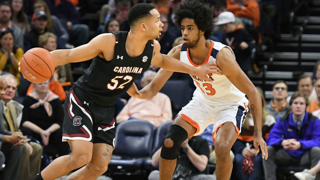 CHARLOTTESVILLE, VA - DECEMBER 22: Jair Bolden #52 of the South Carolina Gamecocks dribbles against Tomas Woldetensae #53 of the Virginia Cavaliers during the first half of a college basketball game at the John Paul Jones Arena on December 22, 2019 in Charlottesville, Virginia.