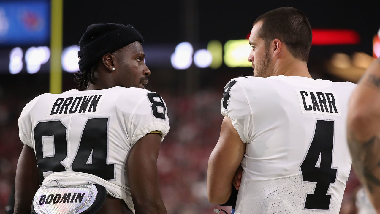 GLENDALE, ARIZONA - AUGUST 15: Wide receiver Antonio Brown #84 and quarterback Derek Carr #4 of the Oakland Raiders talk on the sidelines during the first half of the NFL preseason game against the Arizona Cardinals at State Farm Stadium on August 15, 2019 in Glendale, Arizona.