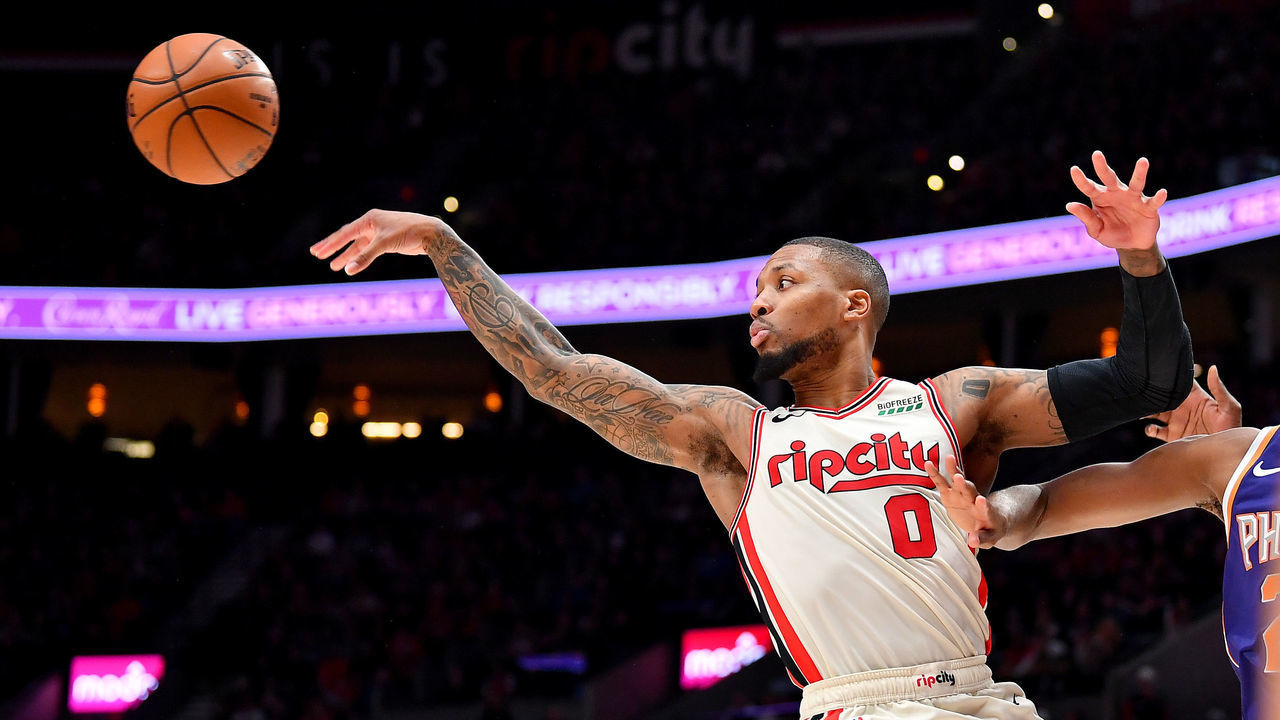 PORTLAND, OREGON - DECEMBER 30: Damian Lillard #0 of the Portland Trail Blazers passes the ball while driving to the basket during the second half of the game against the Phoenix Suns at the Moda Center on December 30, 2019 in Portland, Oregon. The Phoenix Suns top the Portland Trail Blazers 122-116.