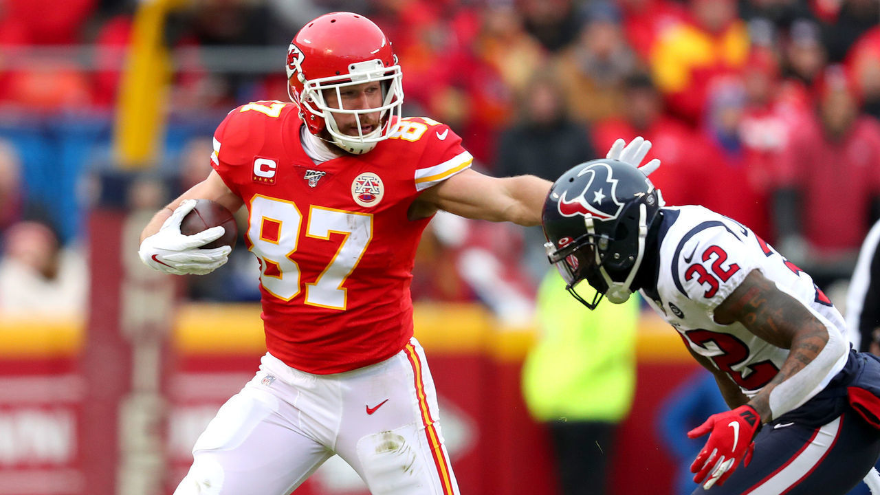 KANSAS CITY, MISSOURI - JANUARY 12: Travis Kelce #87 of the Kansas City Chiefs is pursued by Lonnie Johnson Jr. #32 of the Houston Texans during the first quarter in the AFC Divisional playoff game at Arrowhead Stadium on January 12, 2020 in Kansas City, Missouri.
