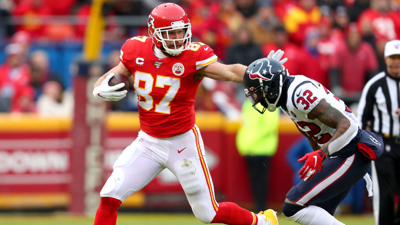KANSAS CITY, MISSOURI - JANUARY 12: Travis Kelce #87 of the Kansas City Chiefs is pursued by Lonnie Johnson Jr. #32 of the Houston Texans during the first quarter in the AFC Divisional playoff game at Arrowhead Stadium on January 12, 2020 in Kansas City, Missouri.
