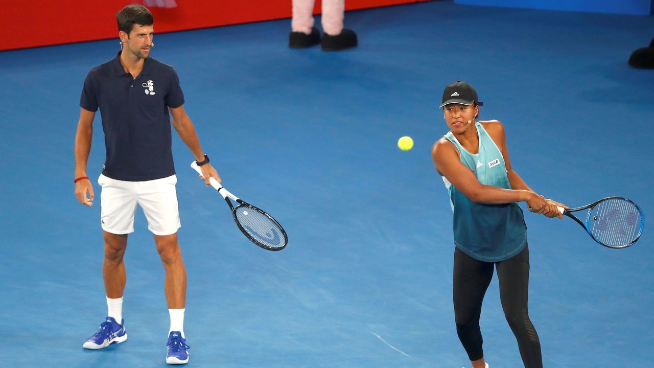 Japan's Naomi Osaka hits a shot as Serbia's Novak Djokovic watches during a kids Day event on Rod Laver Arena ahead of the Australian Open tennis tournament in Melbourne on January 12, 2019.