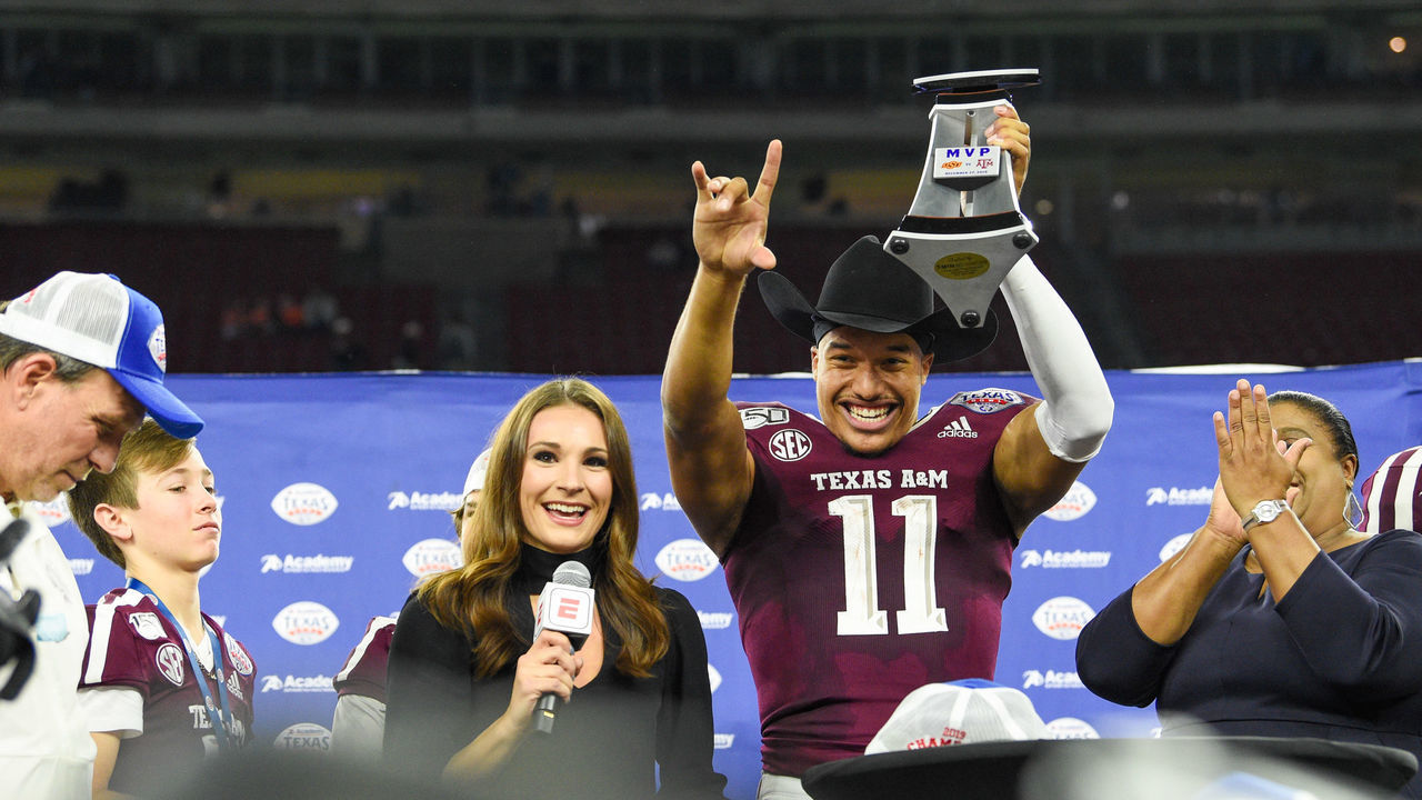 HOUSTON, TX - DECEMBER 27: Texas A&M Aggies quarterback Kellen Mond (11) raises the trophy high after winning MVP honors following the football game between the Oklahoma State Cowboys and Texas A&M Aggies at NRG Stadium on December 27, 2019 in Houston, TX.