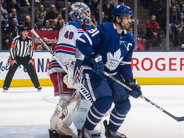TORONTO, ON - DECEMBER 28: John Tavares #91 of the Toronto Maple Leafs battles in front of Alexandar Georgiev #40 of the New York Rangers during the second period at the Scotiabank Arena on December 28, 2019 in Toronto, Ontario, Canada.