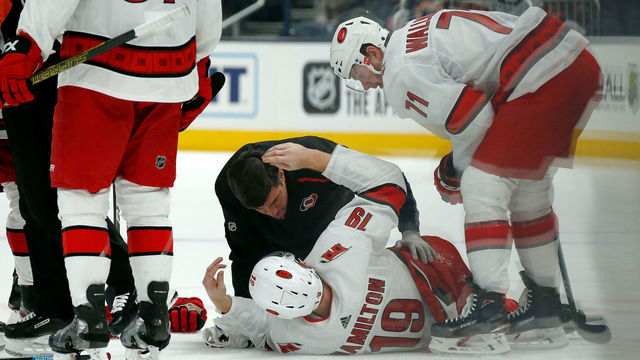 COLUMBUS, OH - JANUARY 16: Dougie Hamilton #19 of the Carolina Hurricanes is checked on by head athletic trainer Doug Bennett after getting injured during the second period against the Columbus Blue Jackets on January 16, 2020 at Nationwide Arena in Columbus, Ohio.
