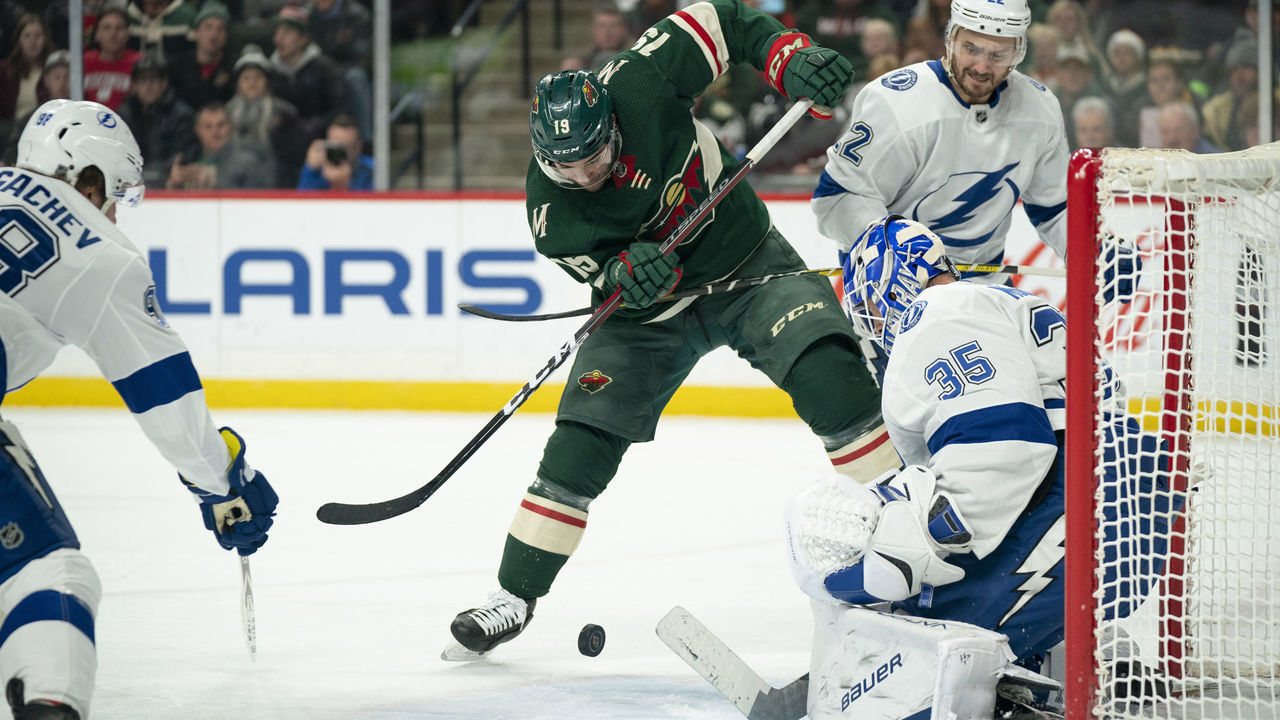 St. Paul, MN January 16: Minnesota Wild center Luke Kunin (19) slapped at a rebound in front of Lightning goaltender Curtis McElhinney (35) with Tampa Bay Lightning defenseman Kevin Shattenkirk (22) defending in the first period.