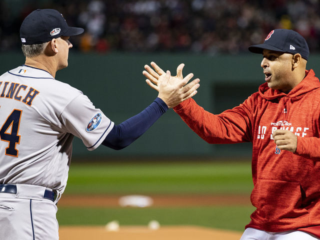 BOSTON, MA - OCTOBER 13: Manager Alex Cora of the Boston Red Sox high fives manager A.J. Hinch of the Houston Astros before game one of the American League Championship Series on October 13, 2018 at Fenway Park in Boston, Massachusetts.