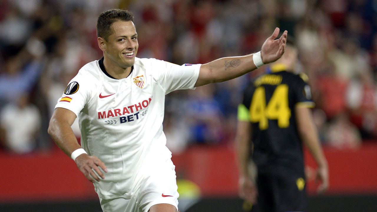 Sevilla's Mexican forward Chicharito (L) celebrates after scoring during the UEFA Europa League group A football match between Sevilla and APOEL Nicosia at the Ramon Sanchez Pizjuan stadium in Seville on October 3, 2019.