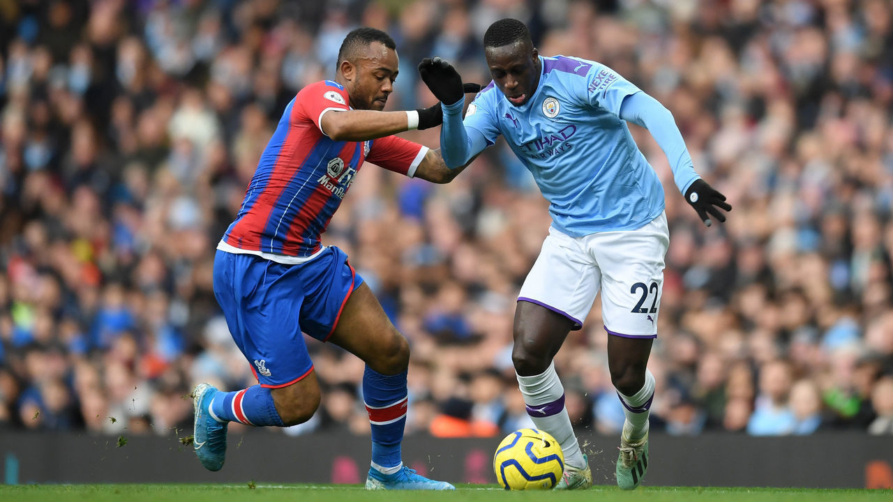 MANCHESTER, ENGLAND - JANUARY 18: Benjamin Mendy of Manchester City battles for possession with Jordan Ayew of Crystal Palace during the Premier League match between Manchester City and Crystal Palace at Etihad Stadium on January 18, 2020 in Manchester, United Kingdom.