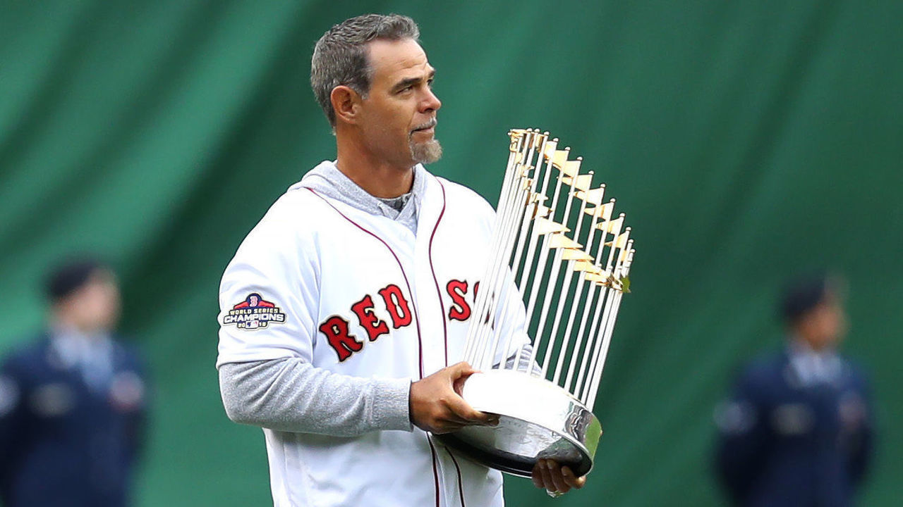 BOSTON, MASSACHUSETTS - APRIL 09: Former MLB player Mike Lowell walks on the field with the 2018 World Series Championship trophy before the home opener at Fenway Park on April 09, 2019 in Boston, Massachusetts.