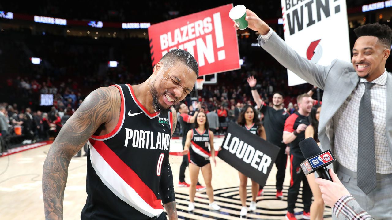 PORTLAND, OREGON - JANUARY 20: Damian Lillard #0 of the Portland Trail Blazers is doused with water by CJ McCollum #3 after scoring a career and franchise high 61 points during their overtime win against the Golden State Warriors at Moda Center on January 20, 2020 in Portland, Oregon.