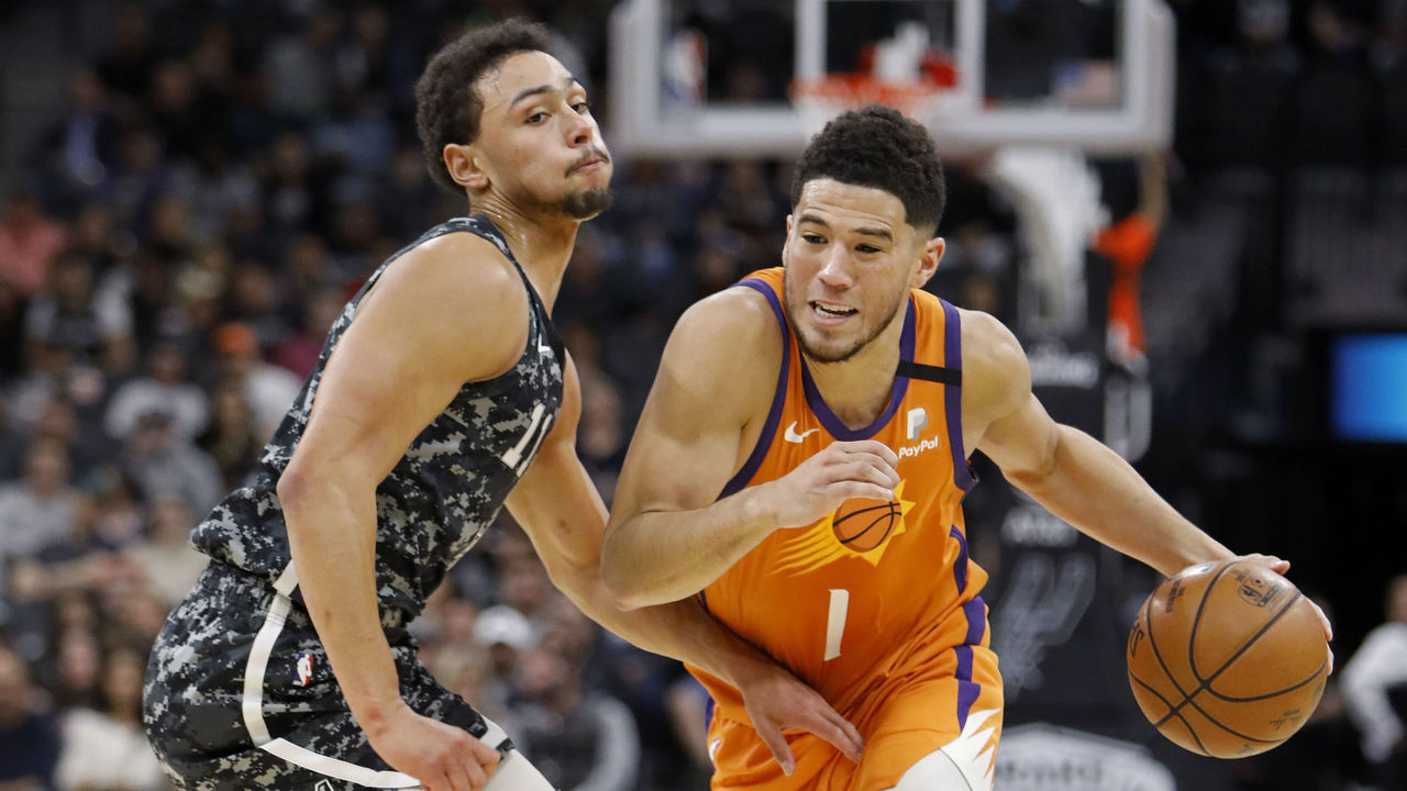 SAN ANTONIO, TX - JANUARY 24: Bryn Forbes #11 of the San Antonio Spurs defends Devin Booker #1 of the Phoenix Suns during an NBA game at the AT&T Center on January 24, 2020 in San Antonio, Texas.