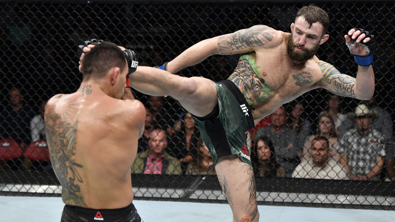 RALEIGH, NORTH CAROLINA - JANUARY 25: (R-L) Michael Chiesa kicks Rafael Dos Anjos of Brazil in their welterweight fight during the UFC Fight Night event at PNC Arena on January 25, 2020 in Raleigh, North Carolina.