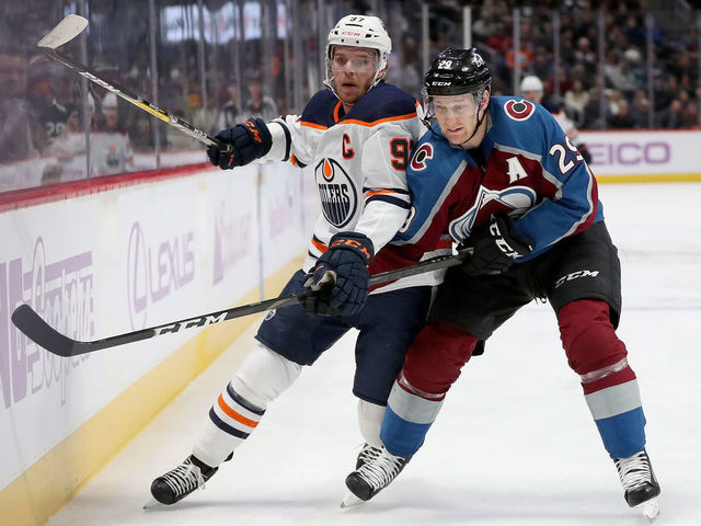 DENVER, COLORADO - NOVEMBER 27: Connor McDavid #97 of the Edmonton Oilers fights for the puck against Nathan MacKinnon #29 of the Colorado Avalanche in the first period at the Pepsi Center on November 27, 2019 in Denver, Colorado.