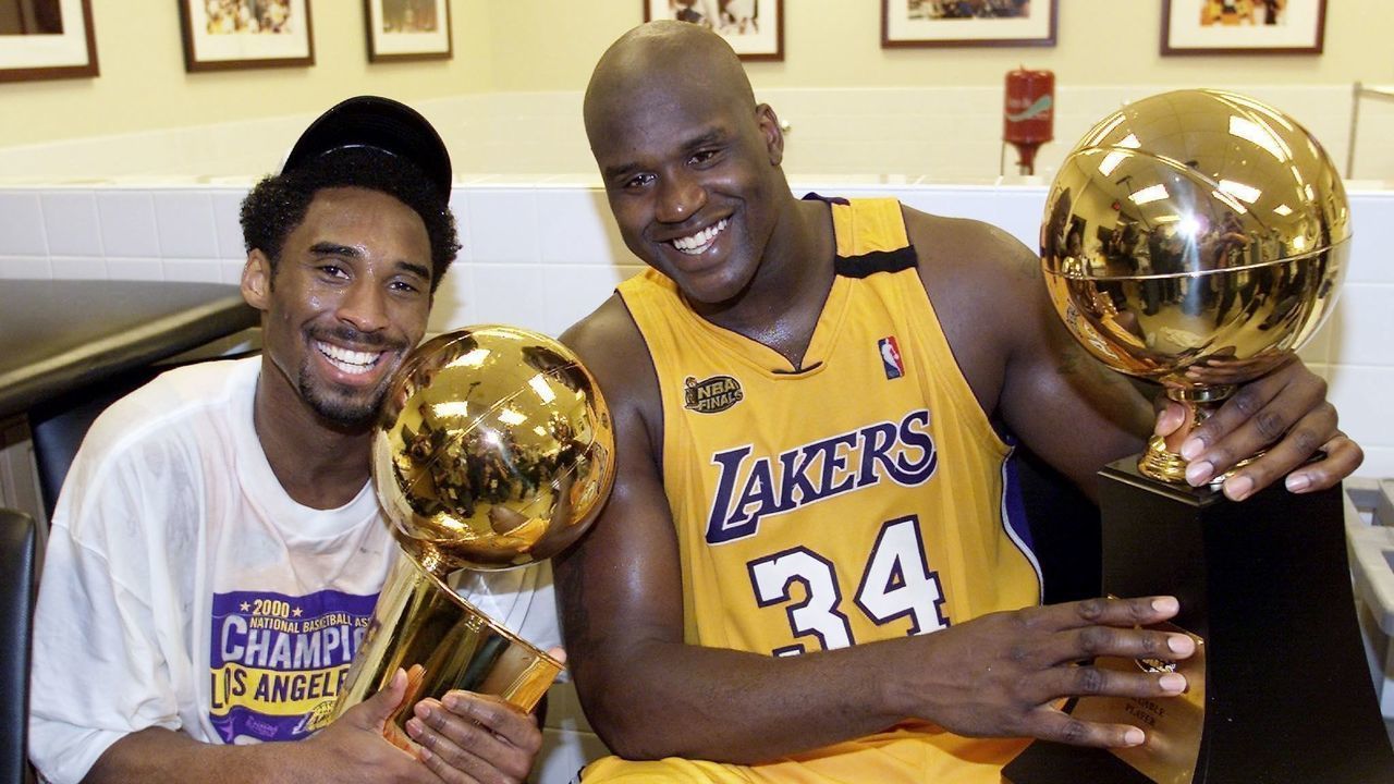 Kobe Bryant (L) of the Los Angeles Lakers holds the Larry O'Brian trophy as teammate Shaquille O'Neal (L) hold the MVP trophy after winning the NBA Championship against Indiana Pacers 19 June, 2000, after game six of the NBA Finals at Staples Center in Los Angeles, CA. The Lakers won the game 116-111 to take the NBA title 4-2 in the best-of-seven series. (ELECTRONIC IMAGE) AFP PHOTO