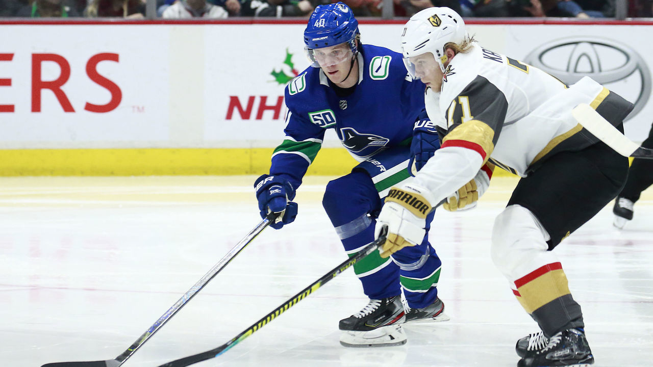 VANCOUVER, BC - DECEMBER 19: William Karlsson #71 of the Vegas Golden Knights and Elias Pettersson #40 of the Vancouver Canucks battle for a loose puck during their NHL game at Rogers Arena December 19, 2019 in Vancouver, British Columbia, Canada. "n
