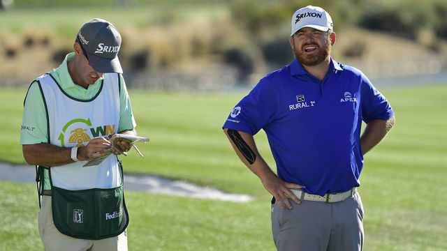 SCOTTSDALE, ARIZONA - JANUARY 31: J.B. Holmes speaks with his caddie on the 18th hole during the second round of the Waste Management Phoenix Open at TPC Scottsdale on January 31, 2020 in Scottsdale, Arizona.