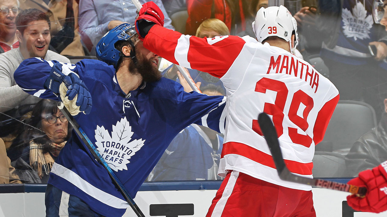 TORONTO, ON - DECEMBER 21: Anthony Mantha #39 of the Detroit Red Wings catches Jake Muzzin #8 of the Toronto Maple Leafs in the head with his stick during an NHL game at Scotiabank Arena on December 21, 2019 in Toronto, Ontario, Canada. The Maple Leafs defeated the Red Wings 4-1.