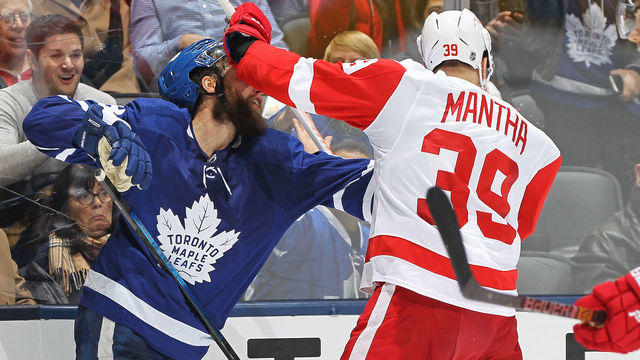 TORONTO, ON - DECEMBER 21: Anthony Mantha #39 of the Detroit Red Wings catches Jake Muzzin #8 of the Toronto Maple Leafs in the head with his stick during an NHL game at Scotiabank Arena on December 21, 2019 in Toronto, Ontario, Canada. The Maple Leafs defeated the Red Wings 4-1.