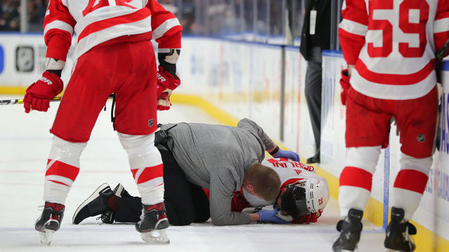 BUFFALO, NY - FEBRUARY 11: A trainer attends to Brendan Perlini #29 of the Detroit Red Wings after getting hurt during the first period against the Buffalo Sabres at KeyBank Center on February 11, 2020 in Buffalo, New York.