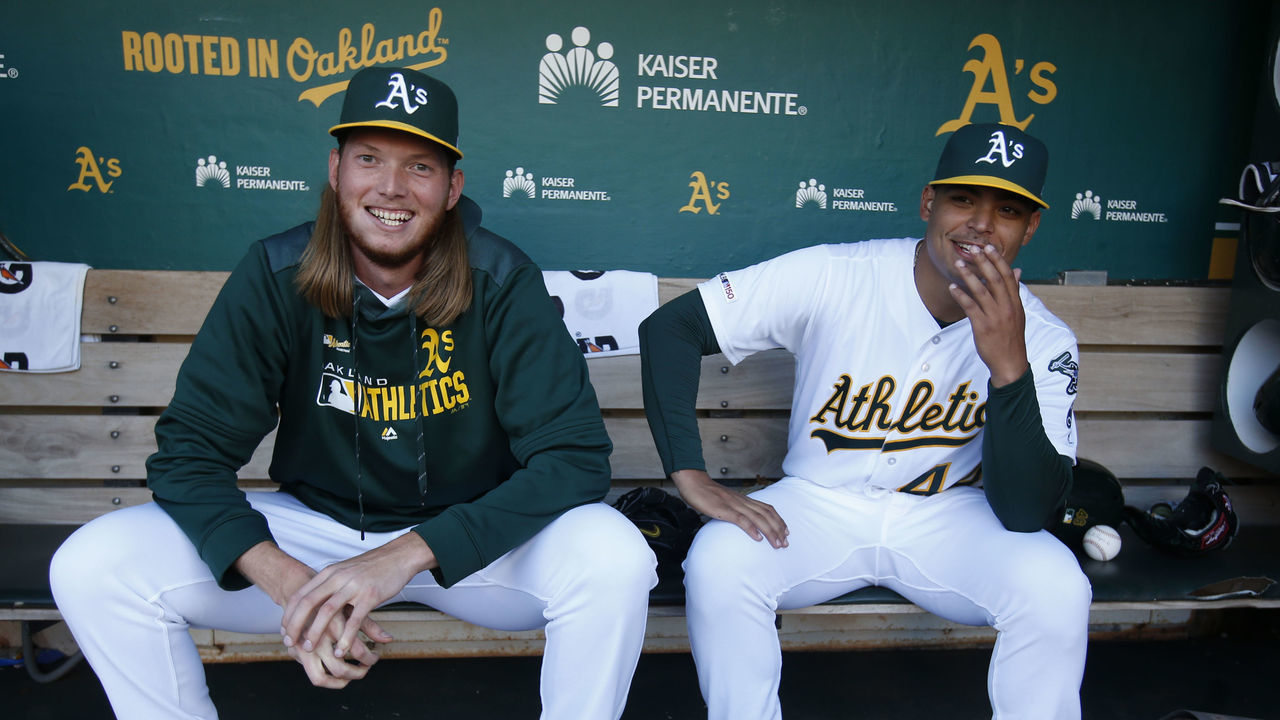 OAKLAND, CA - SEPTEMBER 21: A.J. Puk #31 and Jesus Luzardo #44 of the Oakland Athletics sit in the dugout prior to the game against the Texas Rangers at the Oakland-Alameda County Coliseum on September 21, 2019 in Oakland, California. The Athletics defeated the Rangers 12-3.