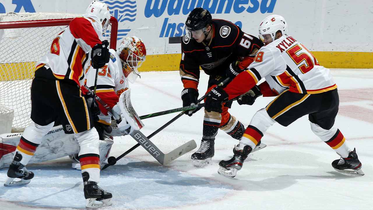 ANAHEIM, CA - FEBRUARY 13: Troy Terry #61 of the Anaheim Ducks battles for the puck against Brandon Davidson #6, Cam Talbot #39, and Oliver Kylington #58 of the Calgary Flames during the game at Honda Center on February 13, 2020 in Anaheim, California.