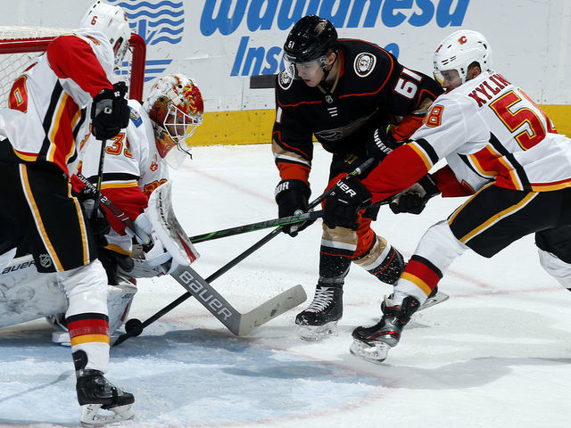 ANAHEIM, CA - FEBRUARY 13: Troy Terry #61 of the Anaheim Ducks battles for the puck against Brandon Davidson #6, Cam Talbot #39, and Oliver Kylington #58 of the Calgary Flames during the game at Honda Center on February 13, 2020 in Anaheim, California.