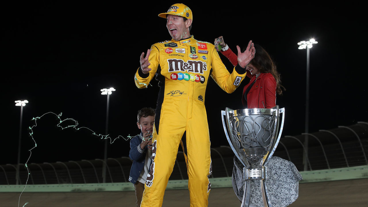 HOMESTEAD, FLORIDA - NOVEMBER 17: Kyle Busch, driver of the #18 M&M's Toyota along with his wife Samantha and son Brexton pose with the trophy after winning the Monster Energy NASCAR Cup Series Championship at Homestead Speedway on November 17, 2019 in Homestead, Florida.