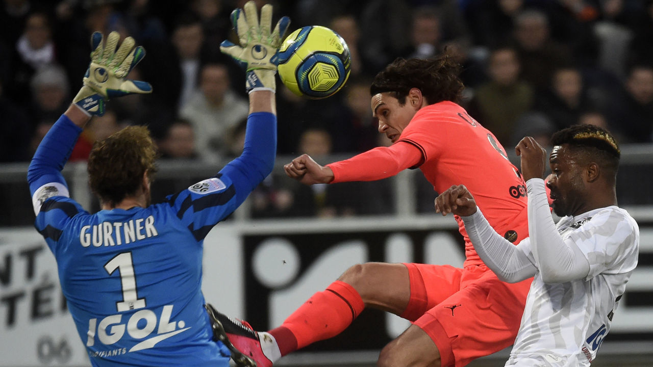 Amiens' French goalkeeper Regis Gurtner (L) stops the ball in front of Paris Saint-Germain's Uruguayan forward Edinson Cavani during the French L1 football match between Amiens SC and Paris Saint-Germain at the Licorne stadium in Amiens, northern France on February 15, 2020.