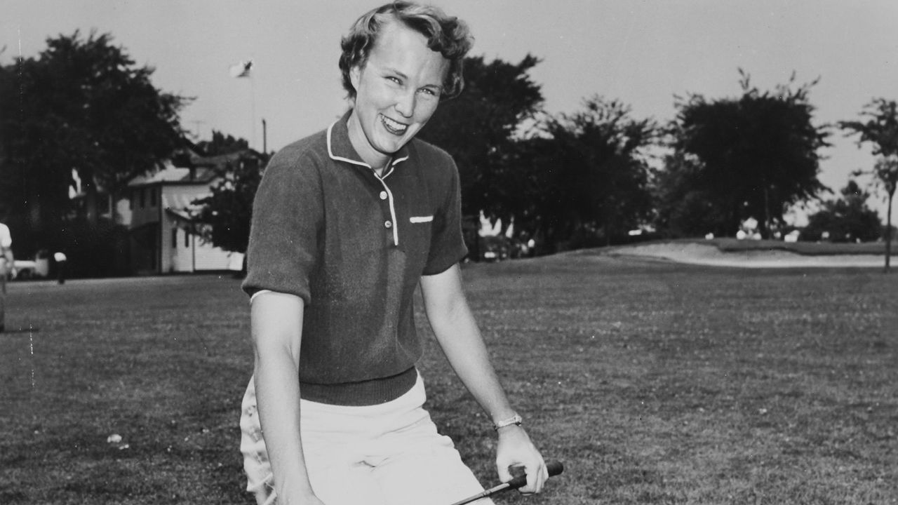 Mickey Wright show off her golf bag and clubs."n-