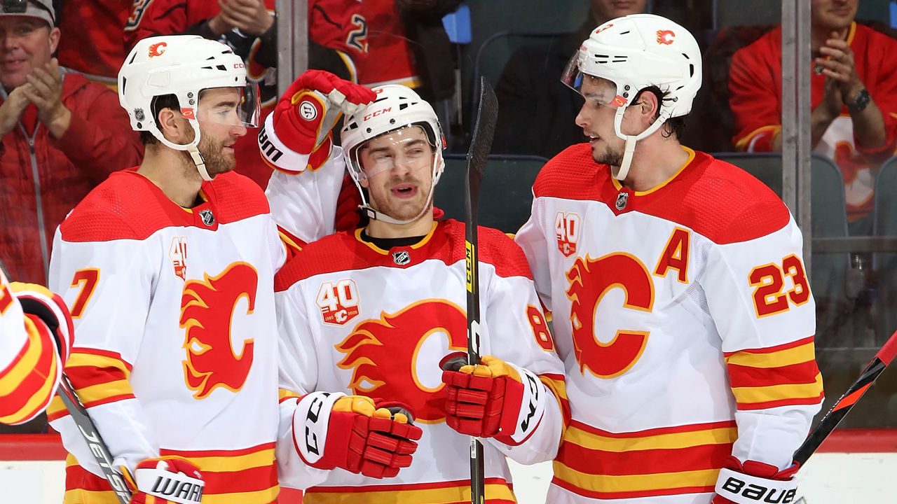 CALGARY, AB - FEBRUARY 17: Andrew Mangiapane #88 of the Calgary Flames celebrates his third goal against the Anaheim Ducks with Sean Monahan #23 and T.J. Brodie #7 of the Calgary Flames during an NHL game on February 17, 2020 at the Scotiabank Saddledome in Calgary, Alberta, Canada.