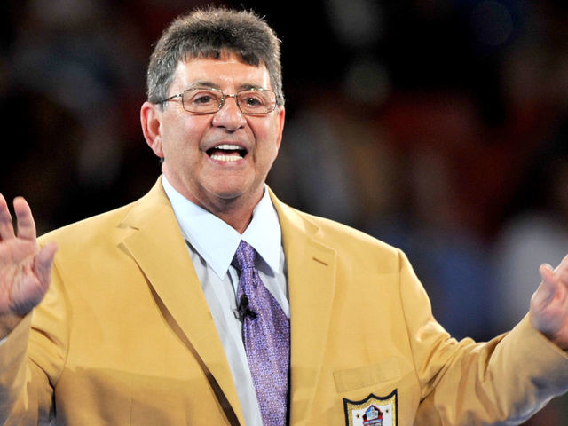 CANTON, OH - AUGUST 4, 2016: 2016 Hall of Fame enshrinee, owner Edward DeBartolo Jr. waves to the crowd after receiving his gold jacket during the Pro Football Hall of Fame Gold Jacket Dinner on August 4, 2016 at the Canton Memorial Civic Center in Canton, Ohio.