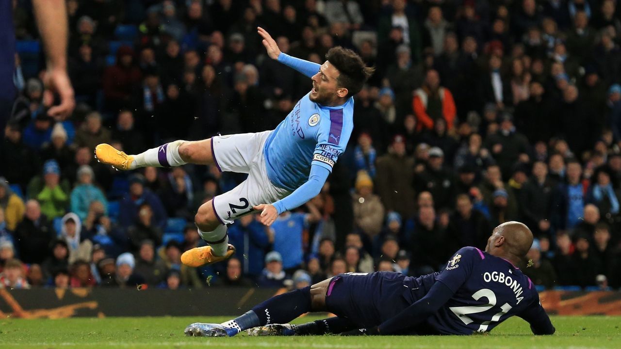 West Ham United's Italian defender Angelo Ogbonna (R) tackles Manchester City's Spanish midfielder David Silva (C) during the English Premier League football match between Manchester City and West Ham United at the Etihad Stadium in Manchester, north west England, on February 19, 2020.