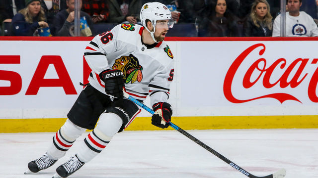 WINNIPEG, MB - FEBRUARY 9: Erik Gustafsson #56 of the Chicago Blackhawks plays the puck down the ice during second period action against the Winnipeg Jets at the Bell MTS Place on February 9, 2020 in Winnipeg, Manitoba, Canada. The Jets defeated the Hawks 5-2.