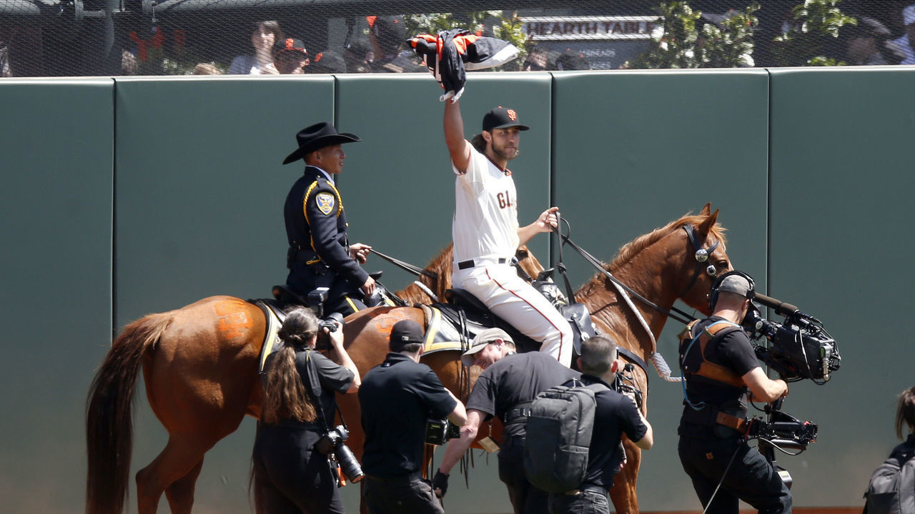 San Francisco Giants starting pitcher Madison Bumgarner (40) raises the championship banner after mounting a horse on his way to deliver the banner to center centerfield before their home opener against the Colorado Rockies at AT&T Park in San Francisco, Calif., on Monday, April 13, 2015. (Nhat V. Meyer/Bay Area News Group)
