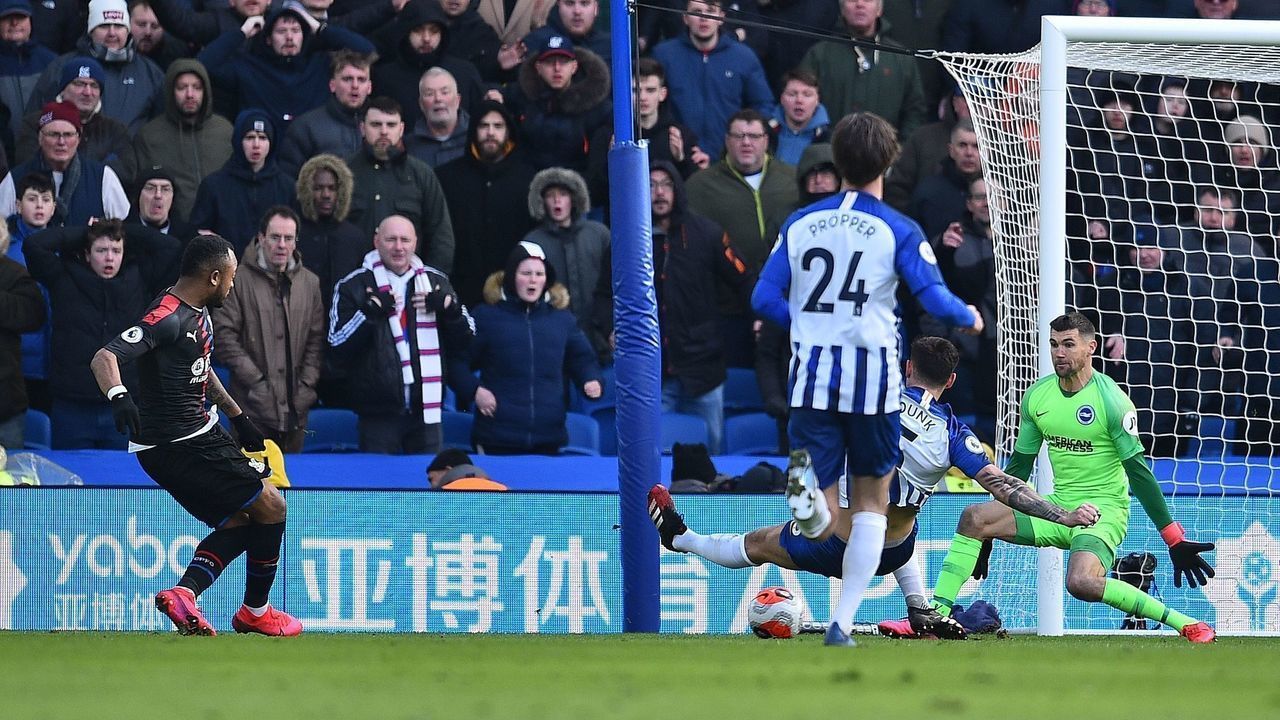 Crystal Palace's French-born Ghanaian striker Jordan Ayew (L) scores the opening goal past Brighton's English defender Lewis Dunk (2R) and Brighton's Australian goalkeeper Mathew Ryan (R) during the English Premier League football match between Brighton and Hove Albion and Crystal Palace at the American Express Community Stadium in Brighton, southern England on February 29, 2020.