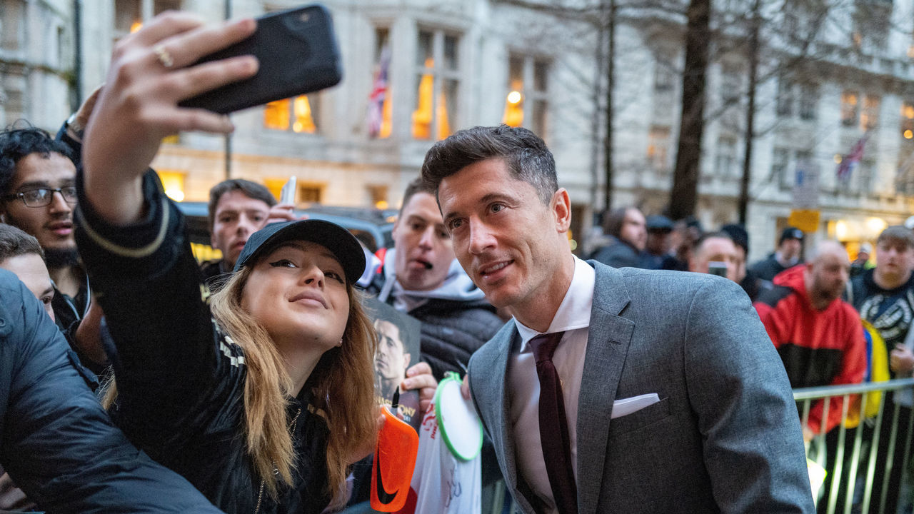 LONDON, ENGLAND - FEBRUARY 24: Robert Lewandowski of FC Bayern Muenchen takes a selfie with a fan after their arrival on February 24, 2020 in London, United Kingdom. FC Bayern Muenchen will play against Chelsea FC in their round of 16 match of the UEFA Champions League on February 25, 2020.