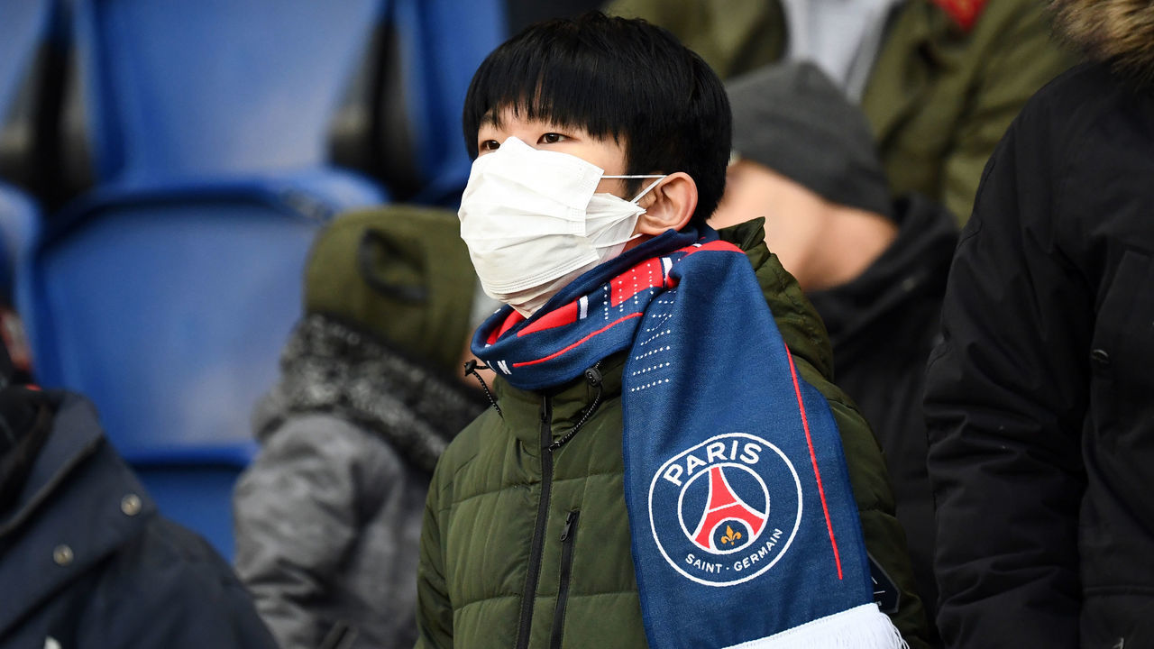 A Paris' supporter wears a protective face mask as a protection against the new coronoavirus, COVID-19 during the French L1 football match between Paris Saint-Germain (PSG) and Dijon, on February 29, 2020 at the Parc des Princes stadium in Paris.